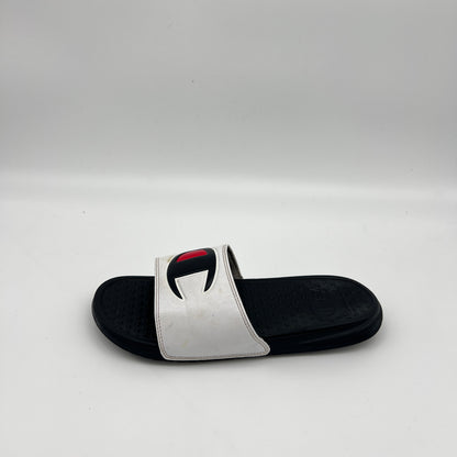White Champion IPO slide sandal with big black and red "C" logo on a black footbed