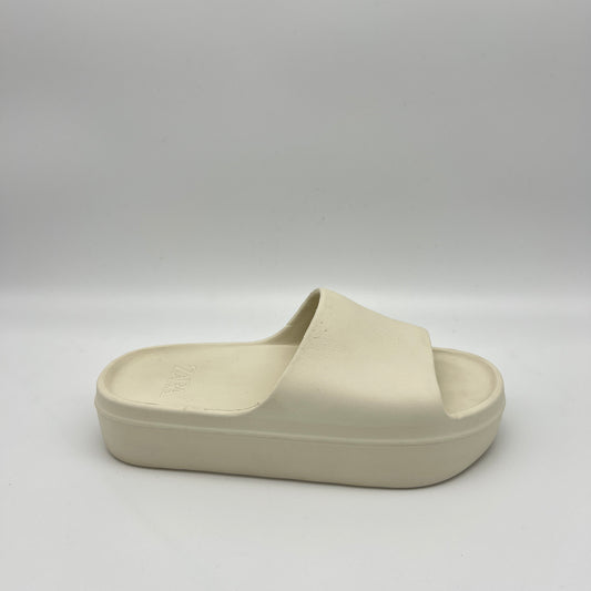 A pair of chunky ivory Zara rubberized platform slides on a neutral background, featuring a thick sole and wide single strap for a minimalist look.