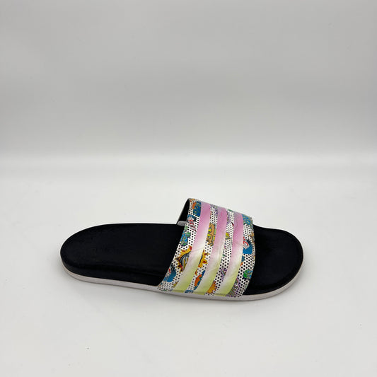 Side view of a black Adidas Adilette Comfort slide with a colorful comic book graphic strap and iridescent stripes on a white background
