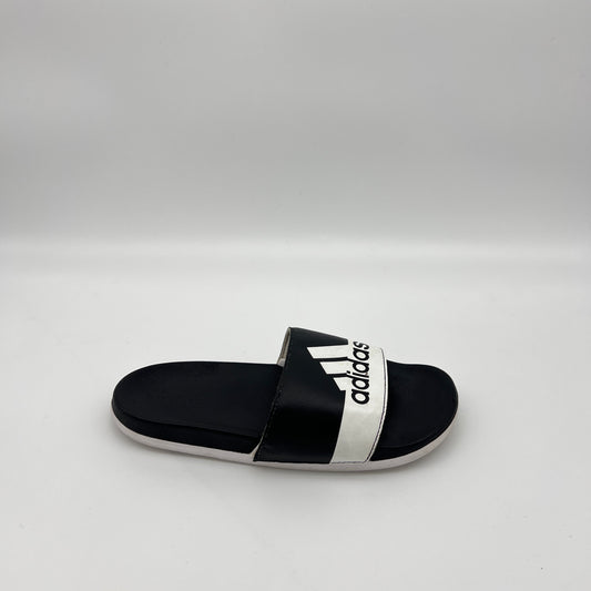 Black adidas Adilette Comfort slide sandal with a white vertical adidas logo on the strap and a black contoured footbed.