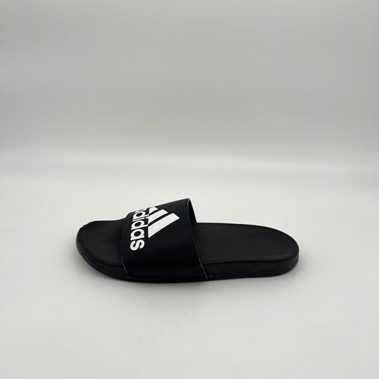 Profile view of a black Adidas Adilette Comfort slide with a white Badge of Sport logo on a clean white background
