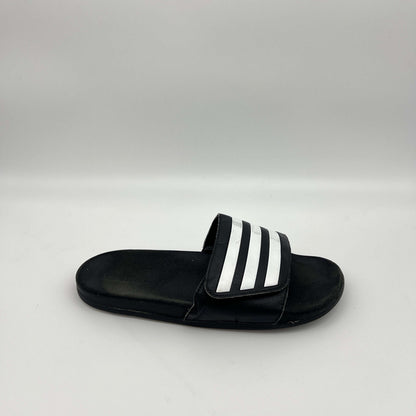 Side profile of a single black adidas Adilette slide sandal with three white iconic stripes on the strap and a smooth footbed on a plain white background.