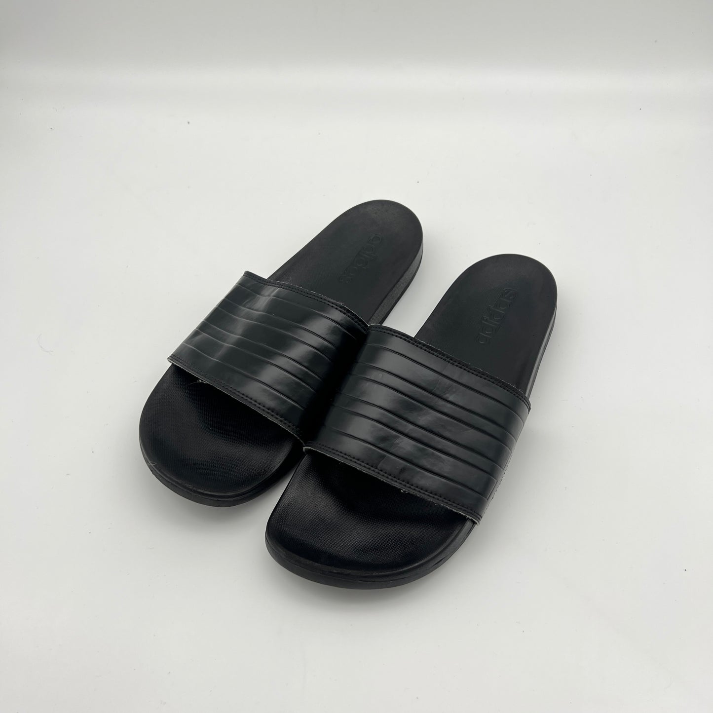 Lightweight adidas Adilette sandals with a contoured sole and signature three-stripe branding.
