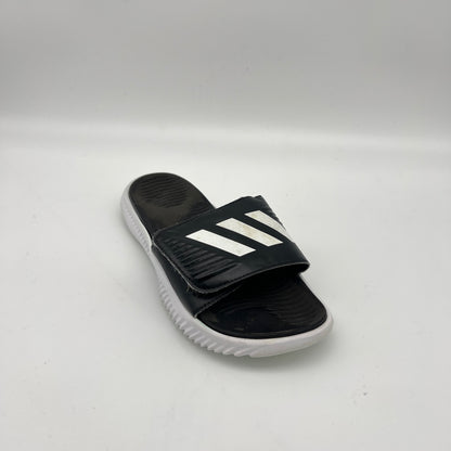 Black slide sandal with white stripes on a light gray background