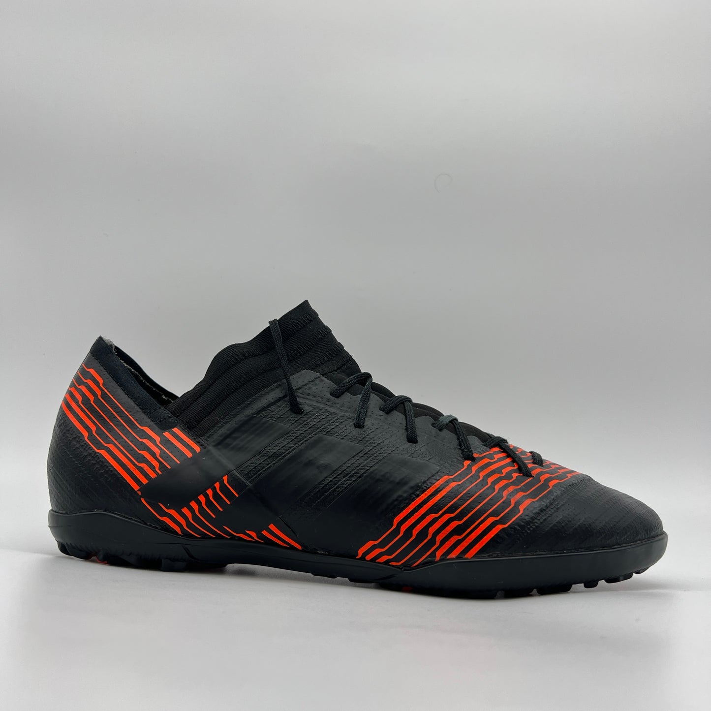 Black adidas Nemeziz Tango 17.3 TF soccer shoe with solar red agility stripes and a supportive mid-cut collar on a white background