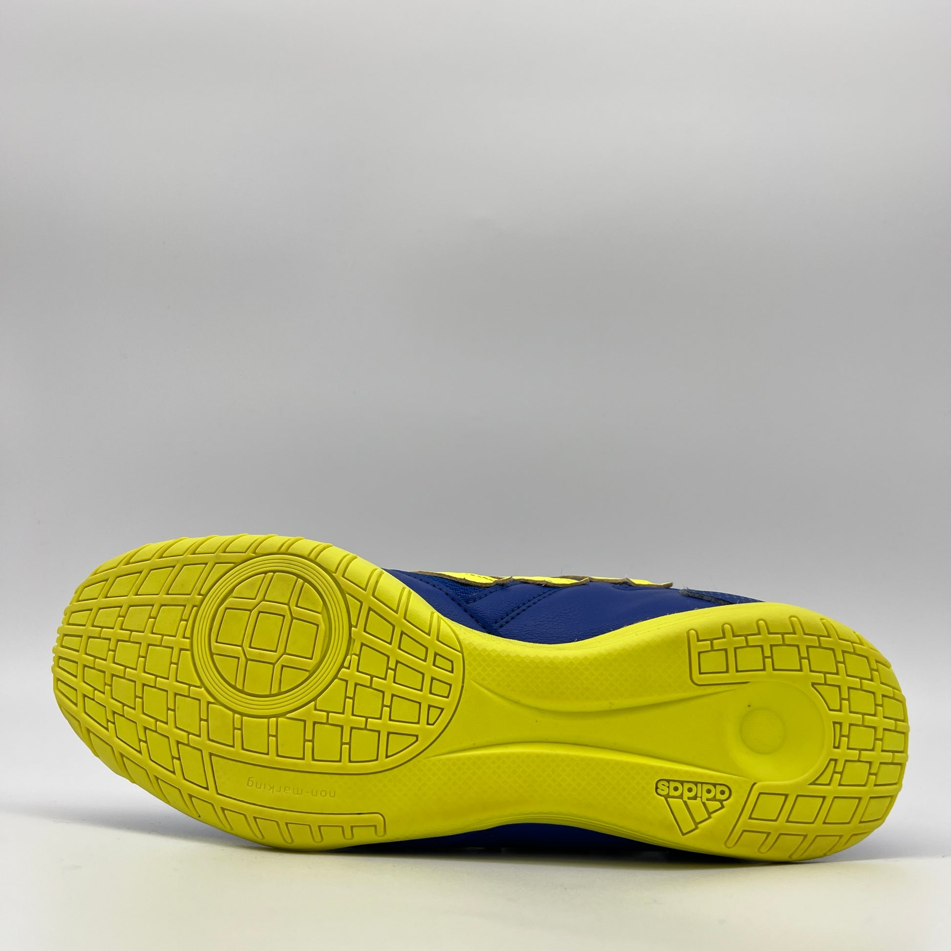 Close-up of a blue and yellow athletic shoe sole on a gray background